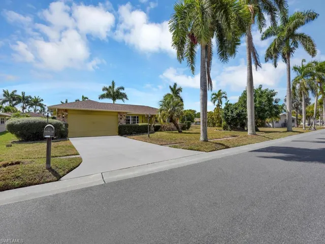 Ranch-style house with a front lawn, a garage, and concrete driveway