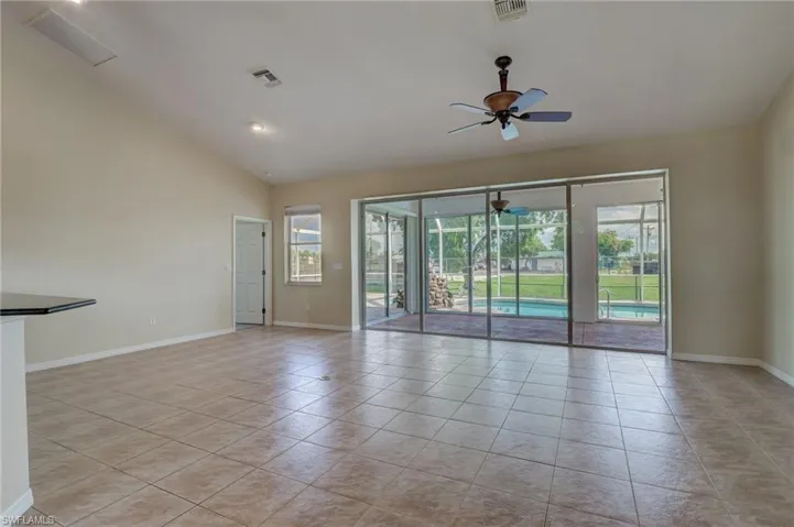 Unfurnished room featuring light tile patterned flooring, high vaulted ceiling, and ceiling fan