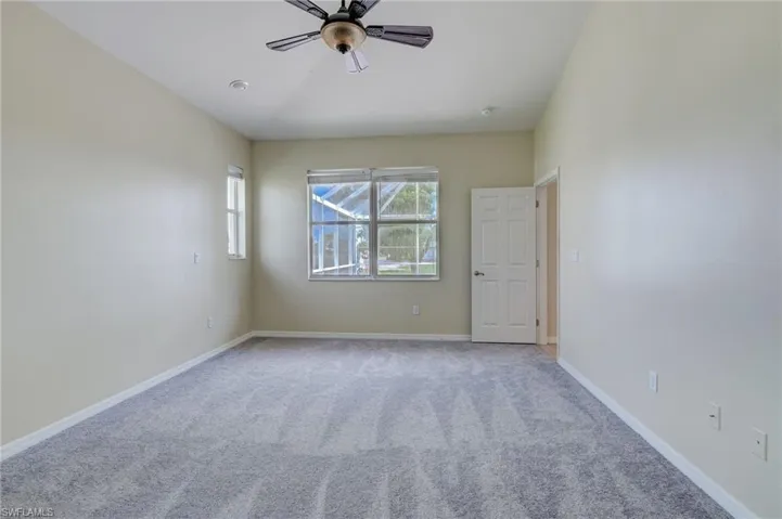 Spare room featuring light carpet and ceiling fan