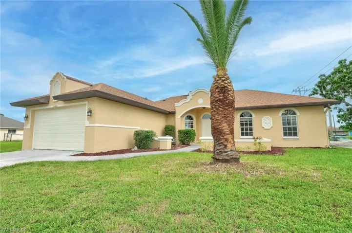 Ranch-style home with a garage and a front lawn