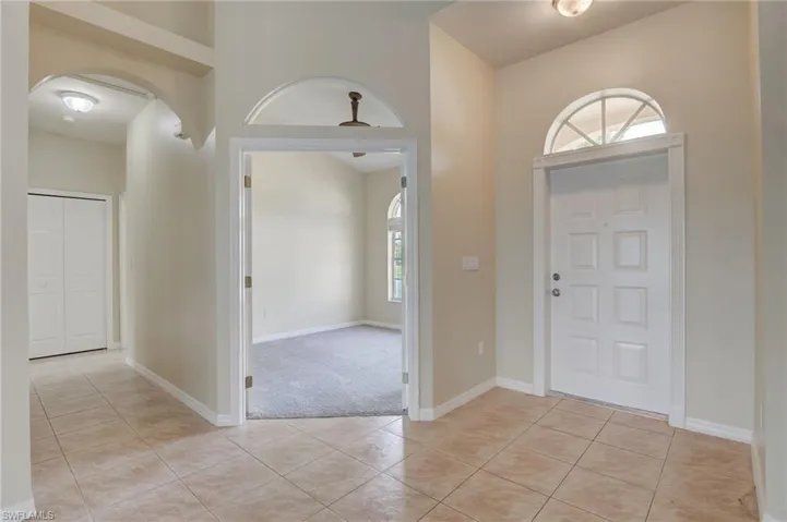 Tiled entrance foyer featuring a towering ceiling