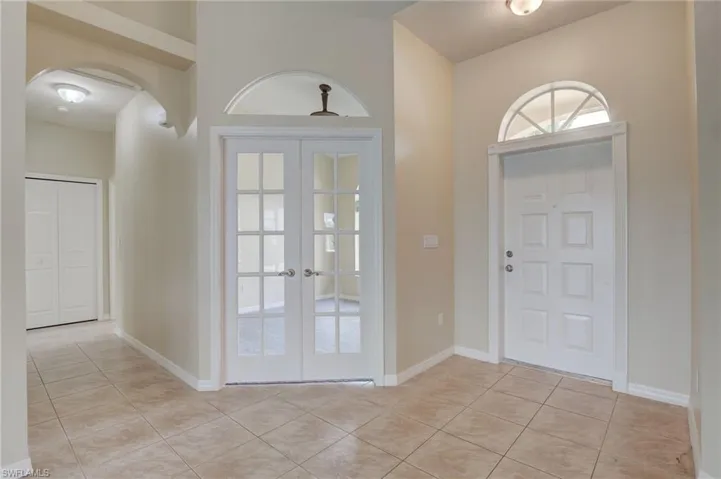 Entryway featuring light tile patterned floors and french doors