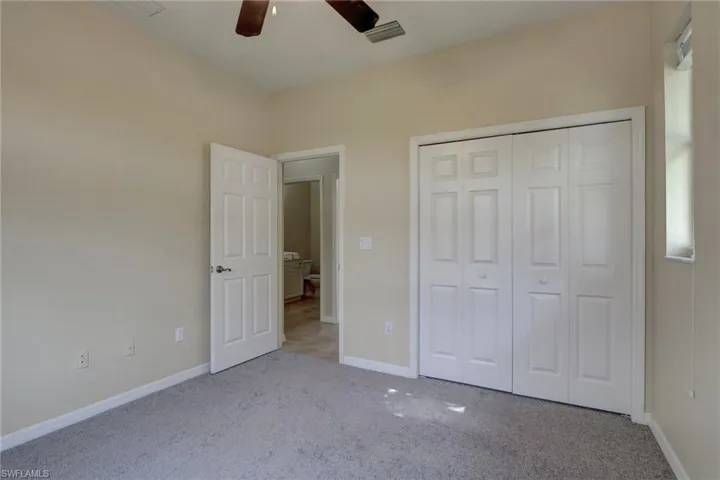 Unfurnished bedroom with light carpet, ceiling fan, and a closet
