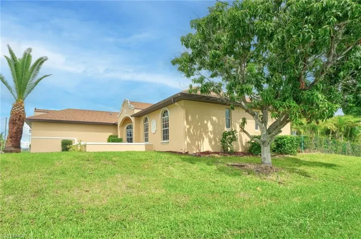 Back of property featuring a lawn