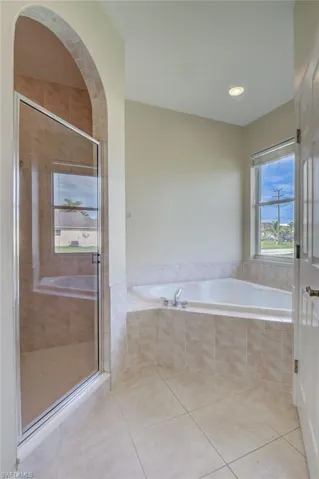 Bathroom with independent shower and bath and tile patterned flooring