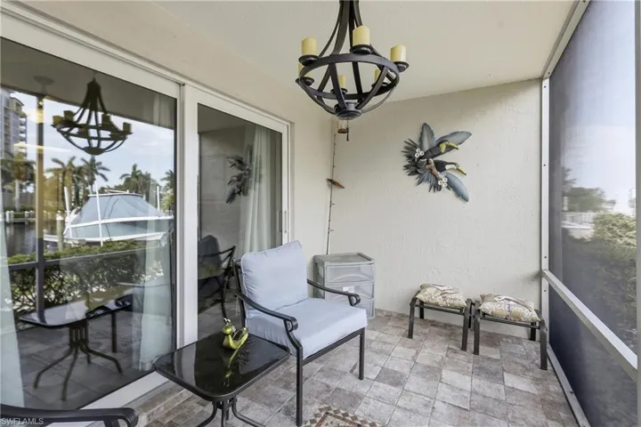 Screened balcony featuring textured walls and tiled flooring