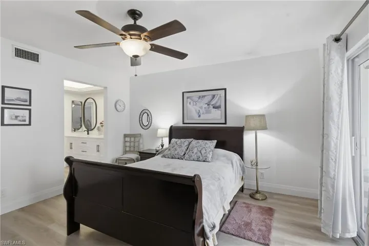 Bedroom featuring light wood-finish flooring, a ceiling fan with integrated lighting, and white walls
