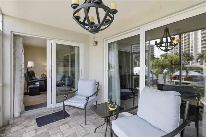 Outdoor patio with stone paver flooring, a vaulted ceiling, and an ornate wrought iron chandelier