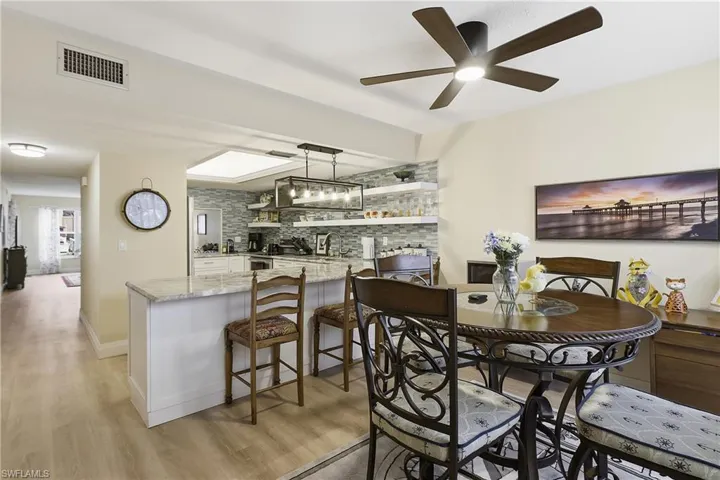 Open-concept living space featuring wood-finish flooring and a contemporary ceiling fan