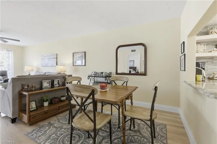 Dining area with wood-finish flooring and light-toned walls
