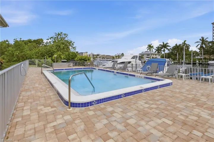 Outdoor swimming pool with tile trim, surrounded by a paver deck