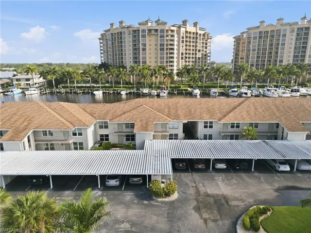 Waterfront multi-story residences with covered parking, featuring a canal with boat slips