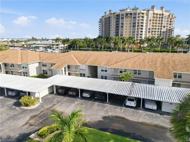 Multi-level apartment complex with covered parking structures and landscaped grounds