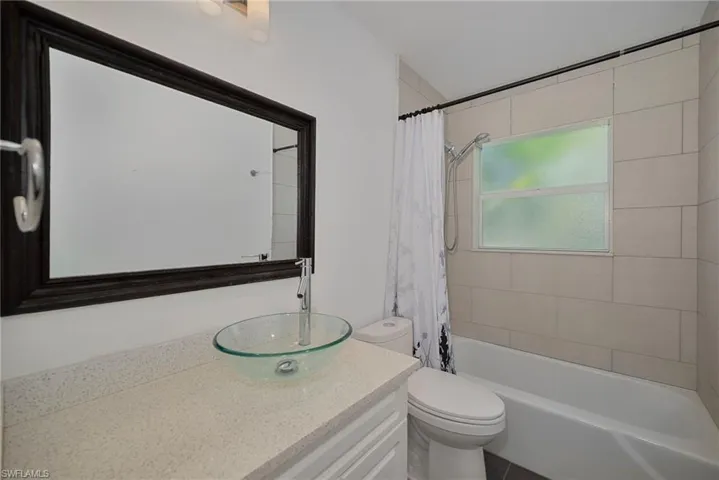 Full bathroom featuring shower / bath combination with curtain and vanity