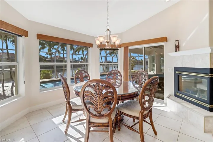 Dining space with light tile patterned floors, a healthy amount of sunlight, and lofted ceiling