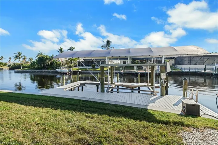 Dock area featuring a water view and a lawn