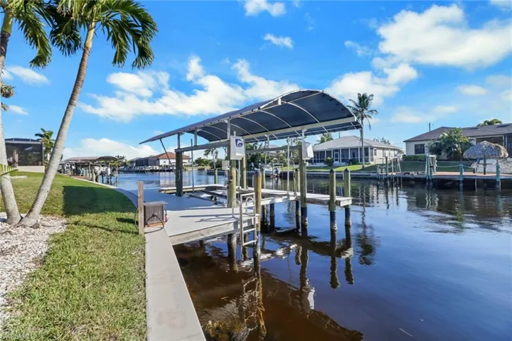 View of dock featuring a water view and a lawn