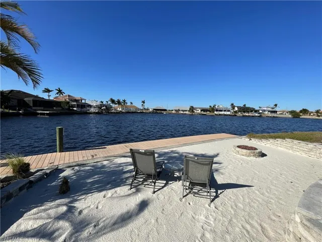 Dock area featuring a water view and a fire pit