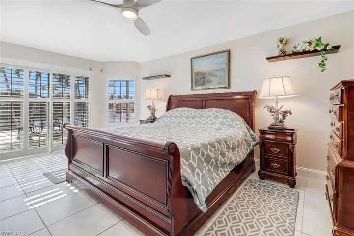 Bedroom with access to exterior, light tile patterned floors, and ceiling fan