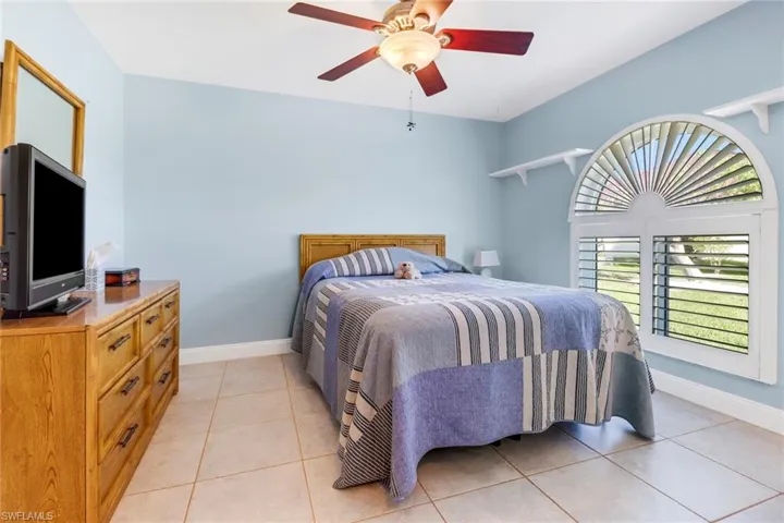 Bedroom with ceiling fan and light tile patterned flooring