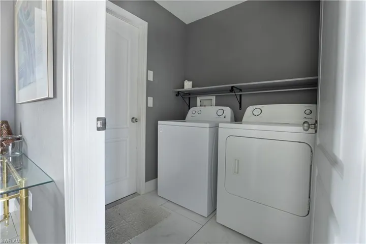 Laundry area with washer and clothes dryer and baseboards
