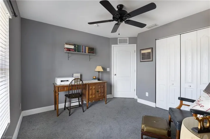 Office with light carpet, plenty of natural light, and ceiling fan
