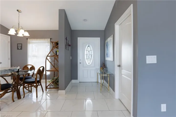 Foyer entrance featuring a chandelier and baseboards