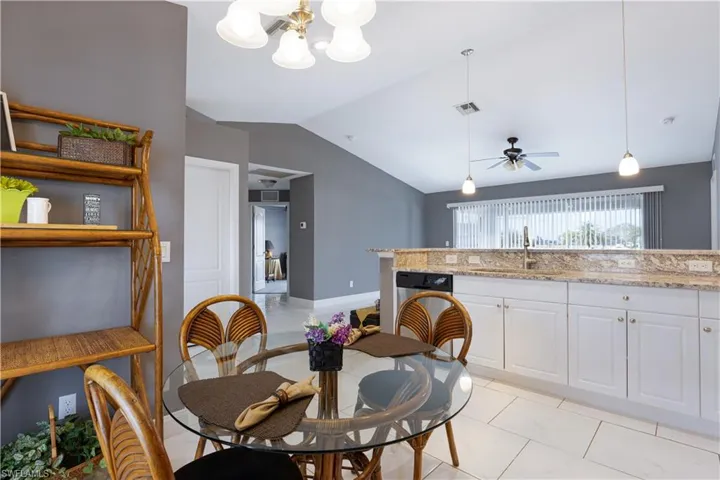 Dining area with lofted ceiling, a chandelier, and a ceiling fan