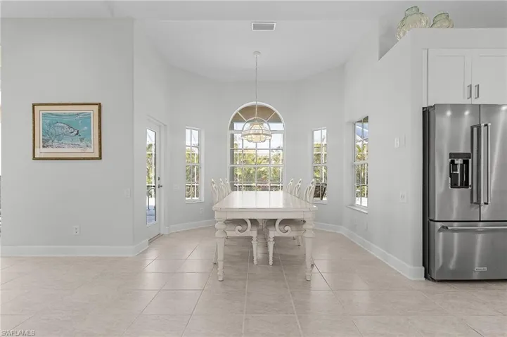 Dining room featuring light tile patterned floors, a chandelier, and a high ceiling