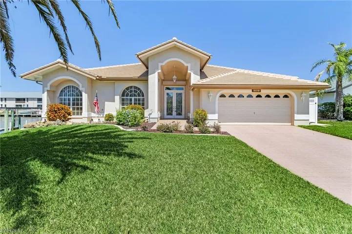Ranch-style home with french doors, a garage, stucco siding, driveway, and a front yard