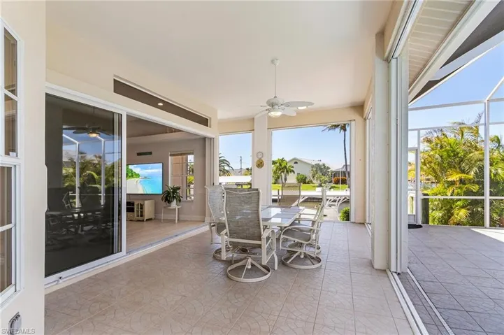 Sunroom featuring ceiling fan and outdoor dining space