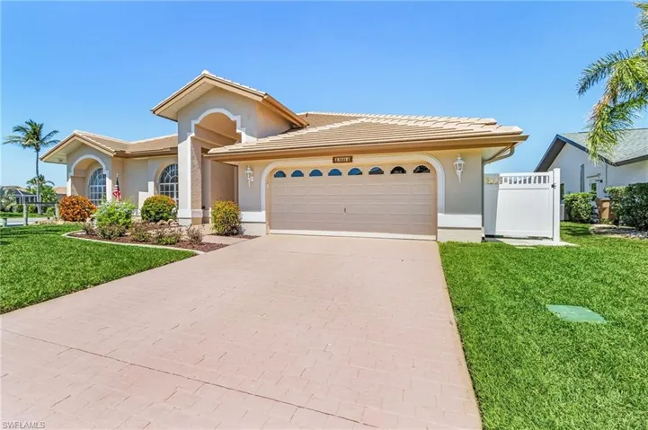 View of front of property with concrete driveway, a garage, stucco siding, and a tiled roof