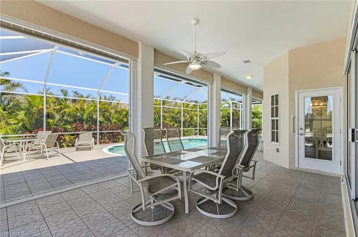 Sunroom featuring a ceiling fan, outdoor dining space, and a swimming pool