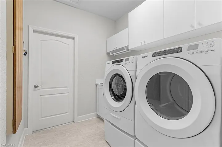 Washroom featuring washer and dryer and cabinet space