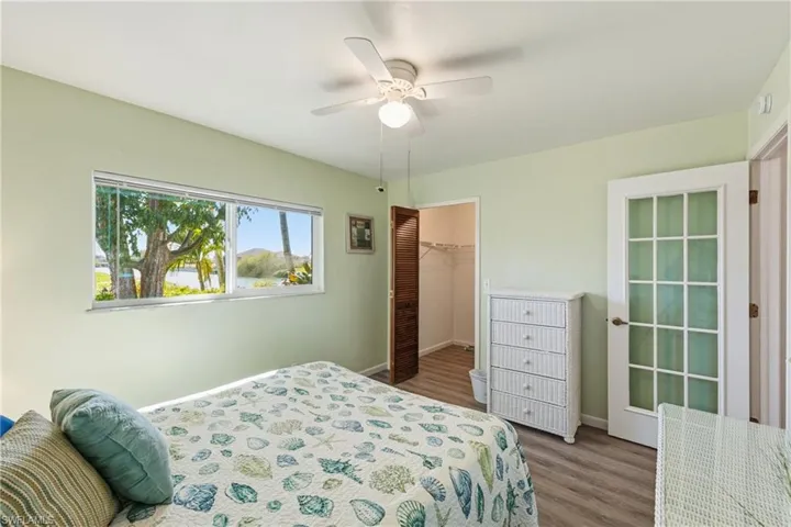 Bedroom featuring a spacious closet, wood finished floors, and a ceiling fan