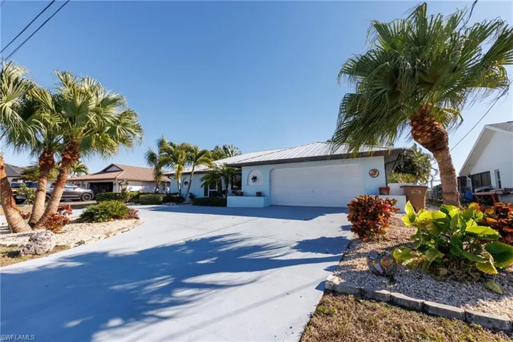 Ranch-style home featuring driveway, an attached garage, and stucco siding