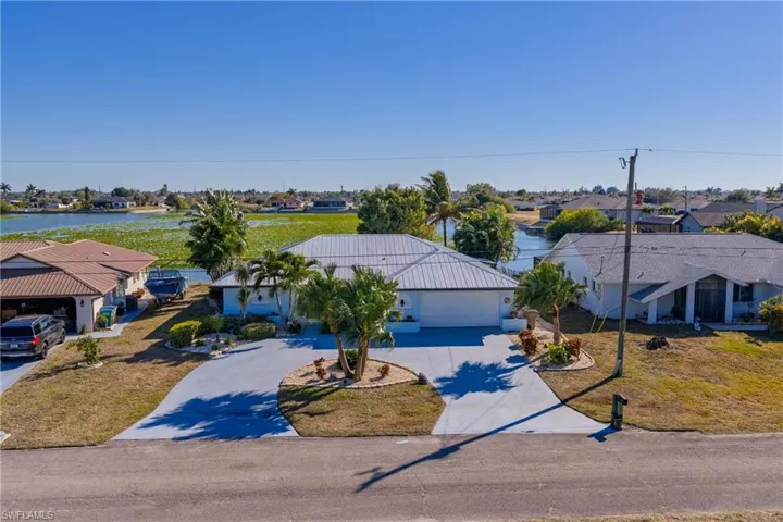 View of front of home featuring concrete driveway, a residential view, a front lawn, and an attached garage
