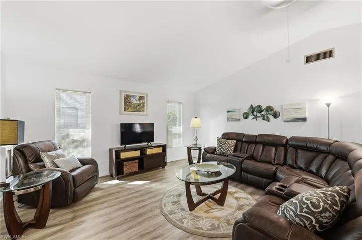 Living room featuring lofted ceiling and wood finished floors