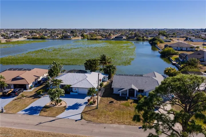 Aerial view of residential area featuring a nearby body of water