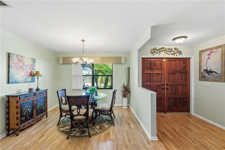 Dining area with suspended lighting and light wood-style flooring