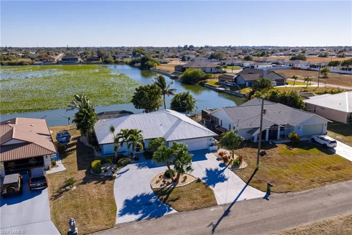 Aerial view of residential area featuring a nearby body of water