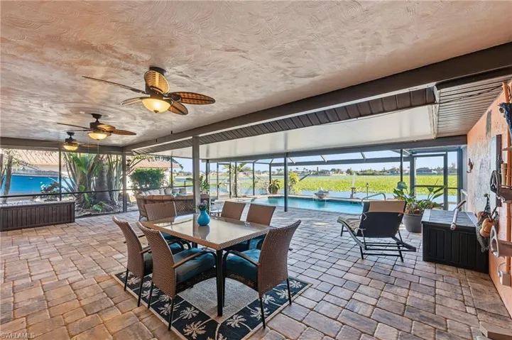 Sunroom / solarium with outdoor dining area, ceiling fan, a patio, and a pool