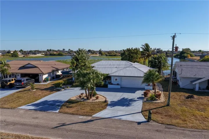 Ranch-style home with driveway, an attached garage, and a front lawn