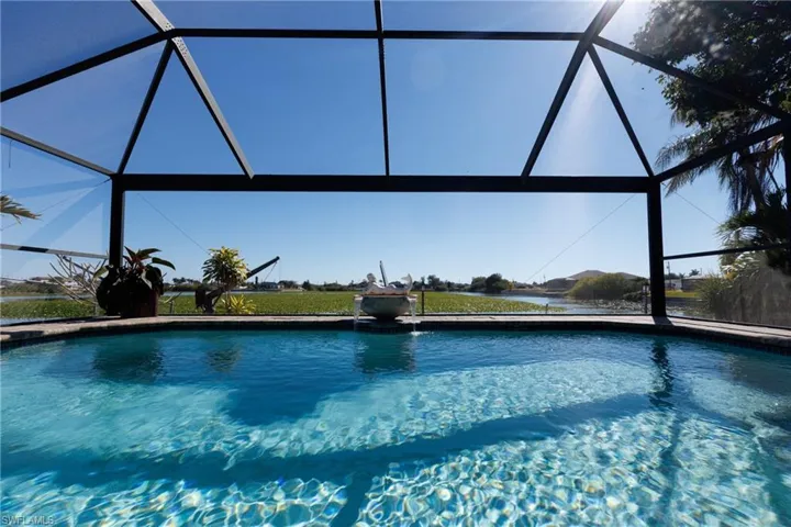 Outdoor pool featuring glass enclosure and a sunroom