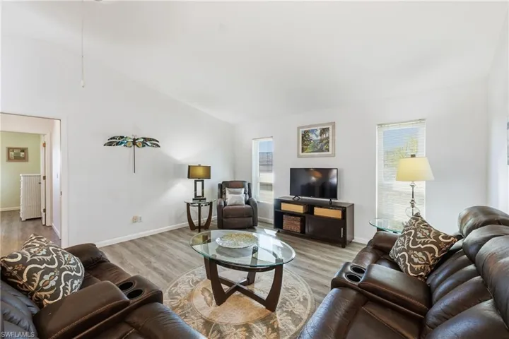 Living room with wood finished floors and vaulted ceiling