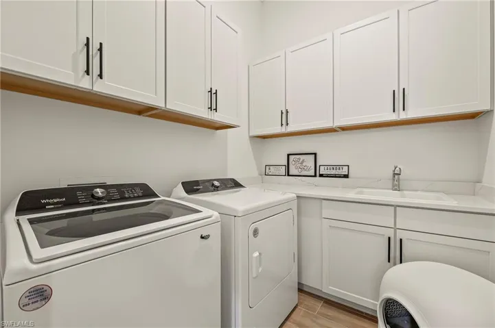 Laundry room with updated appliances, sink, and storage
