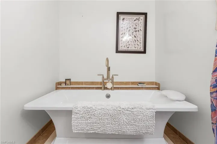 Guest Bathroom featuring tile patterned flooring, a tub, and sink