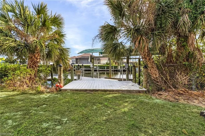 View of yard with a water view and a dock