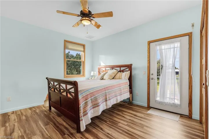 Owner's Bedroom featuring wood-type vinyl flooring, access to outside, and ceiling fan