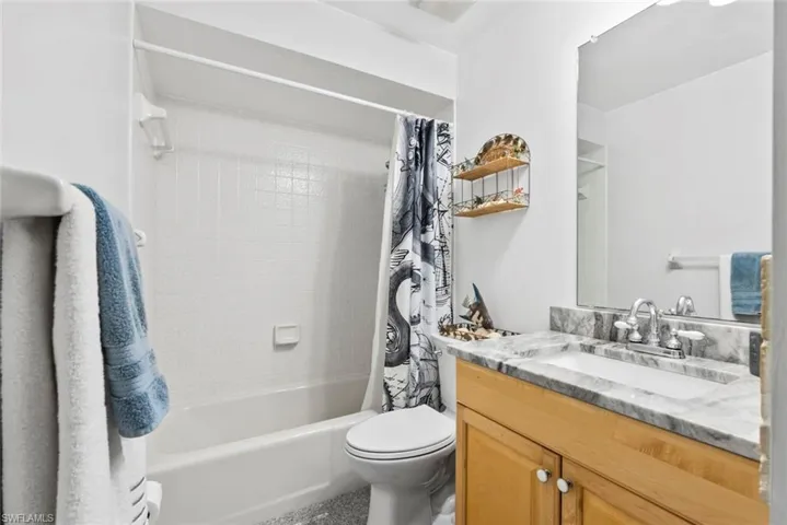 Full bath with shower / bath combination with curtain, vanity, and toilet